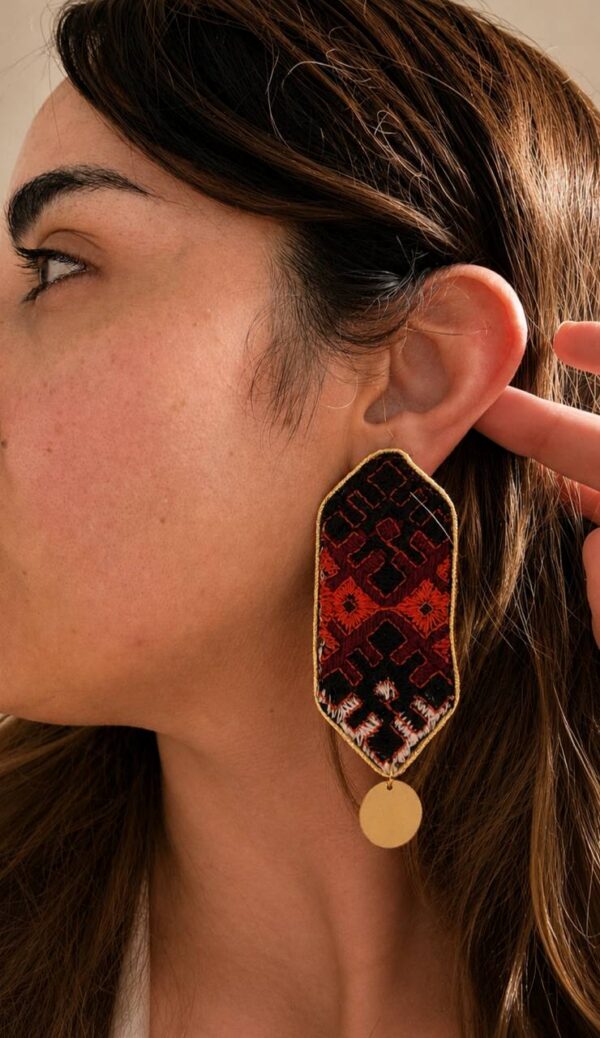 photo_2026-08-30_19-26-06 Model wearing long embroidered earrings with round gold-tone drops