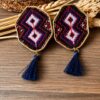 White double-diamond embroidered earrings with red details and navy tassels