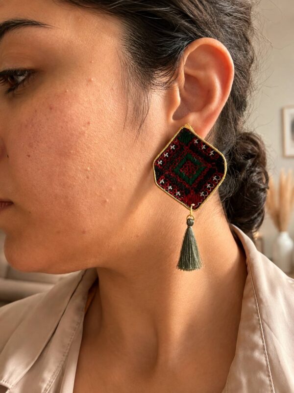Model wearing red and green diamond embroidered earrings with tassels