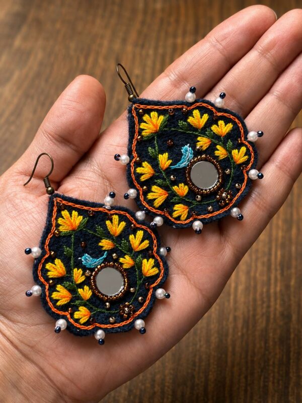 Navy embroidered earrings with yellow flowers blue bird motifs and white bead edging