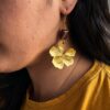 Handmade Golden Blossom copper earrings with textured flower pendant and deep red bead
