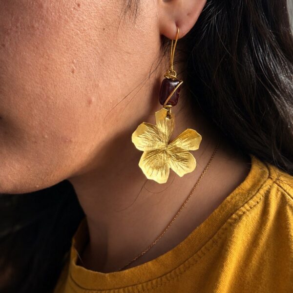 Handmade Golden Blossom copper earrings with textured flower pendant and deep red bead